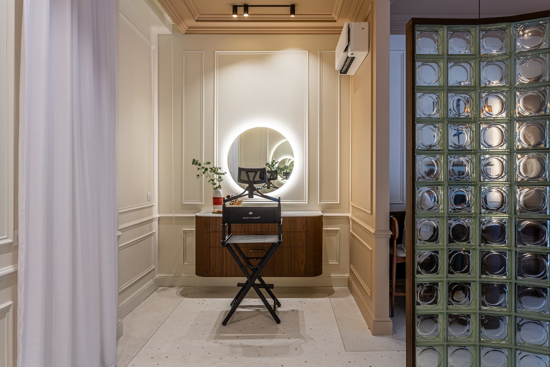 Coiffeuse et paroi en briques de verre dans un appartement rénové par Groupe RSM